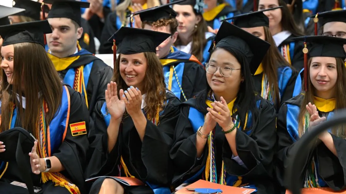 A group of graduates clapping.