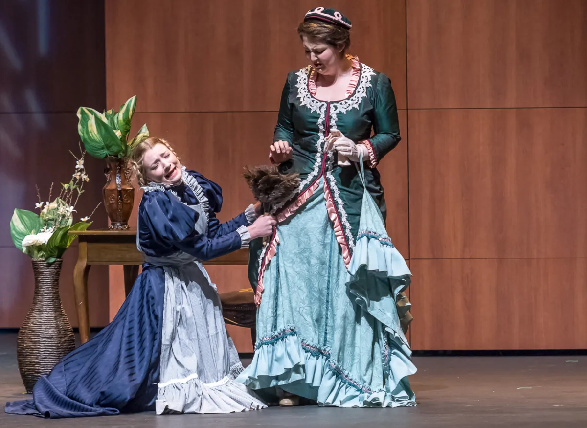 A theatrical scene shows performers onstage