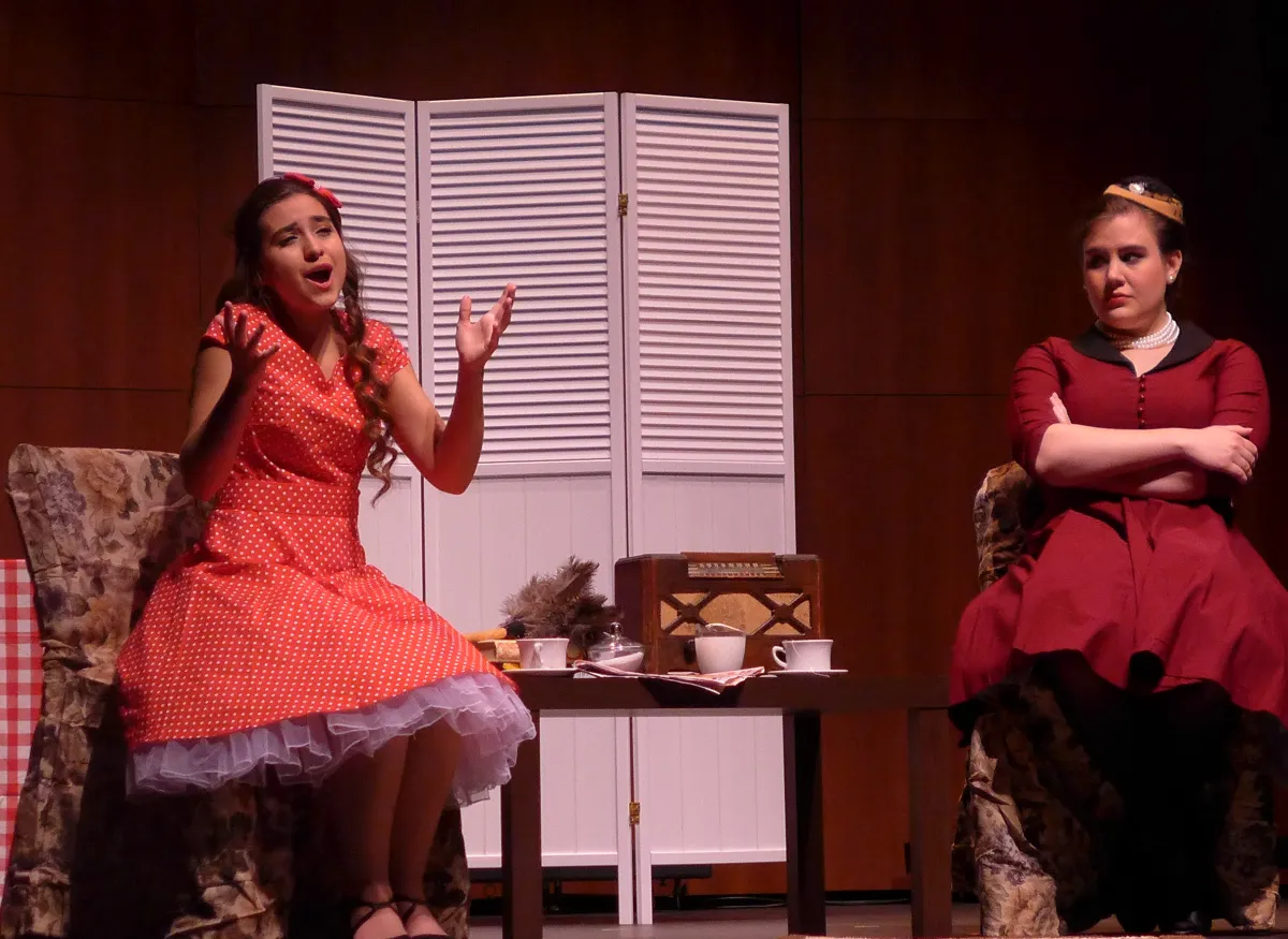 A theatrical scene shows performers onstage