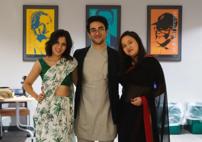 Three people posing indoors in traditional clothing