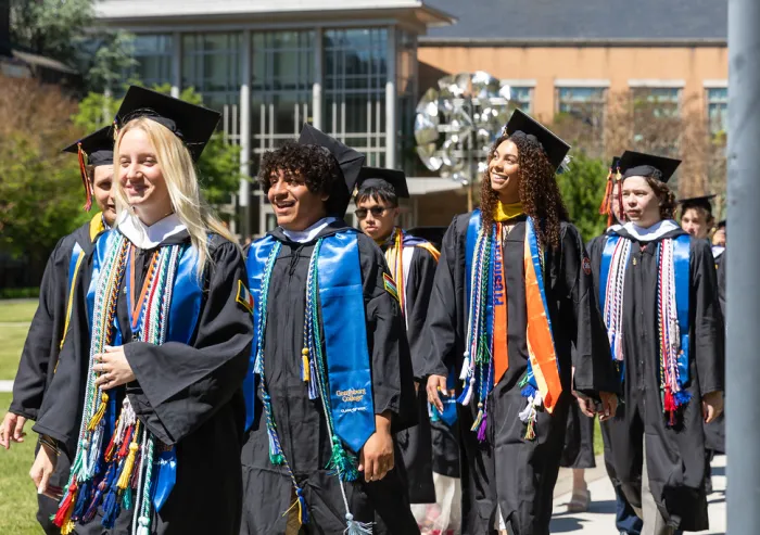 A group of graduates walking down the pathway