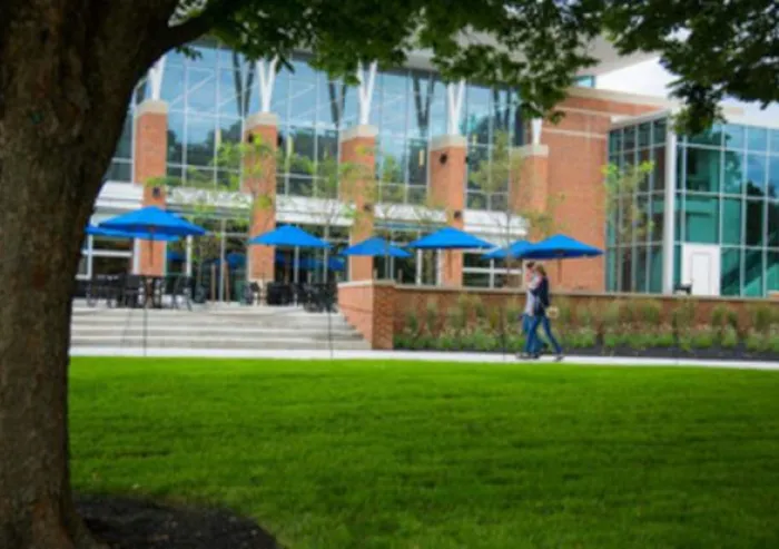 Two students walk along the path ajacent to CUB green.