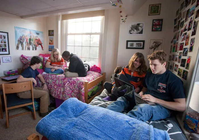 Students sit in a dorm room.