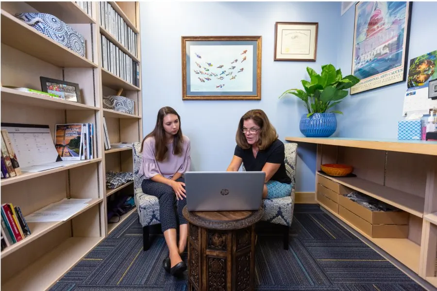 female prof and student work at laptop together
