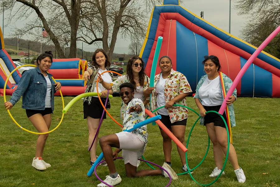 students pose outside with hula hoops and pool noodles