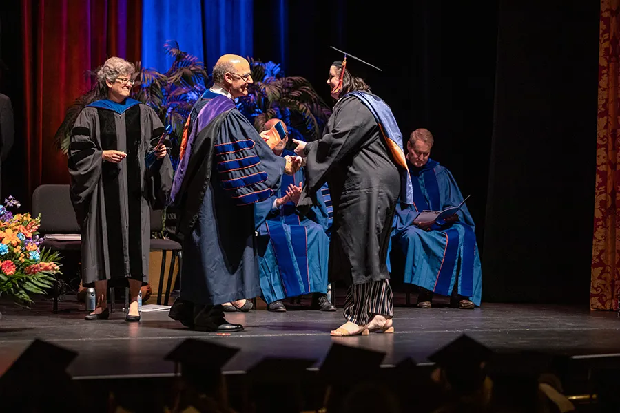 President Iuliano congratulates female Masters grad