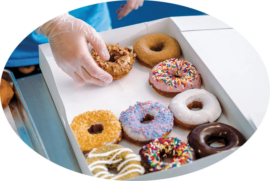 A man picking up a donut