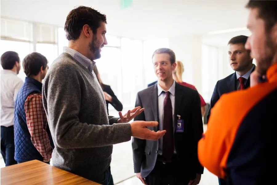 group of alumni converse in well-lit room