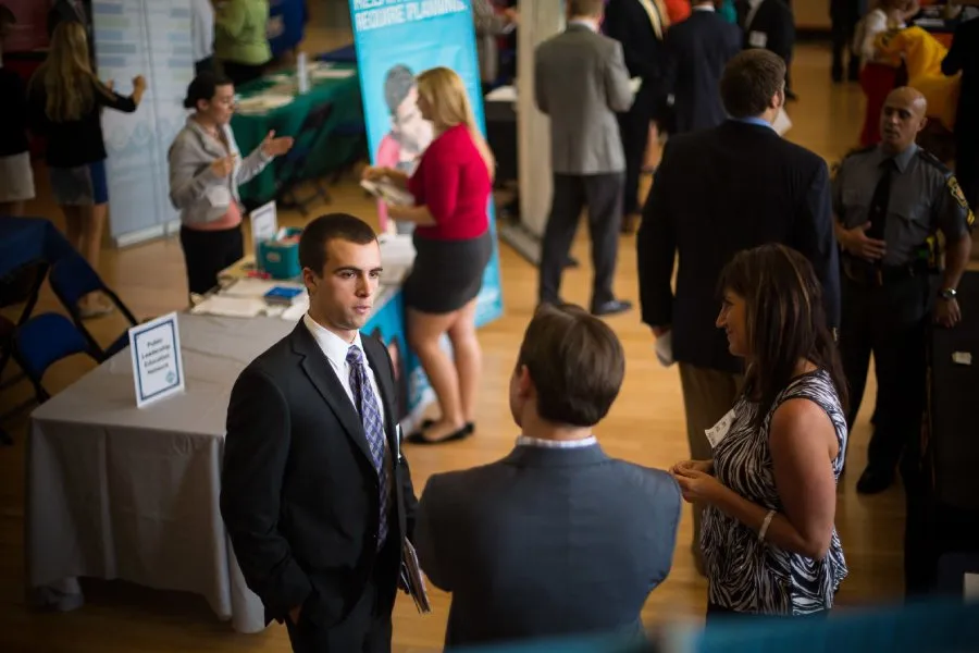 male student speaks with potential employers at career fair