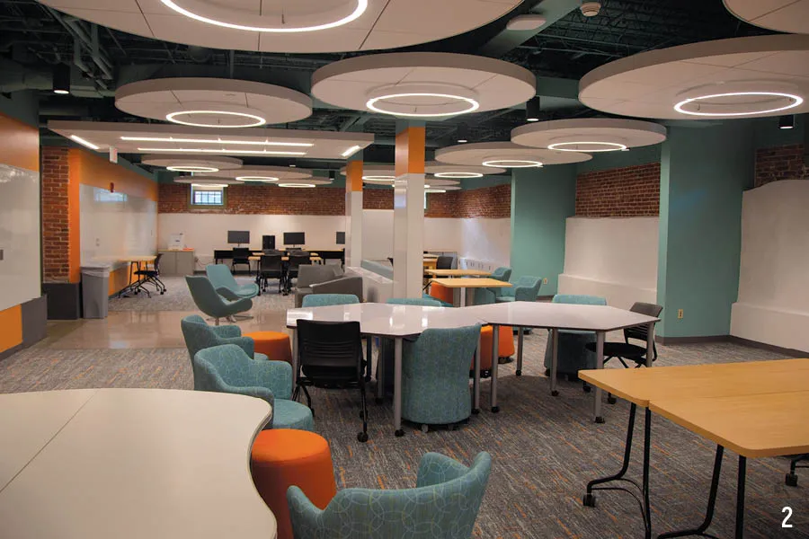 lounge space with futuristic seating, lighting, and lots of tables and whiteboard on walls