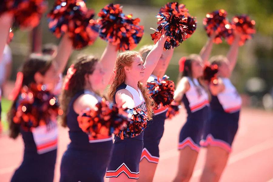 cheerleaders hold up pompoms