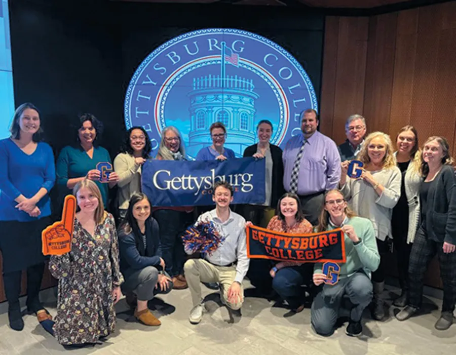 A photo of a group of students posing together and holding Gettsbrg College banners