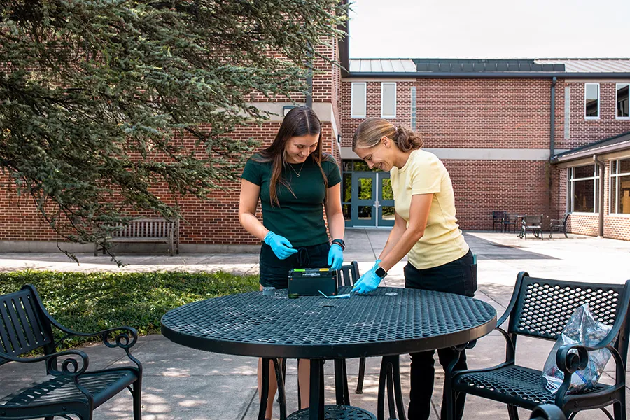 Prof. Megan Benka-Coker and Bramley Hawkins ’26 setting up an air quality detection device