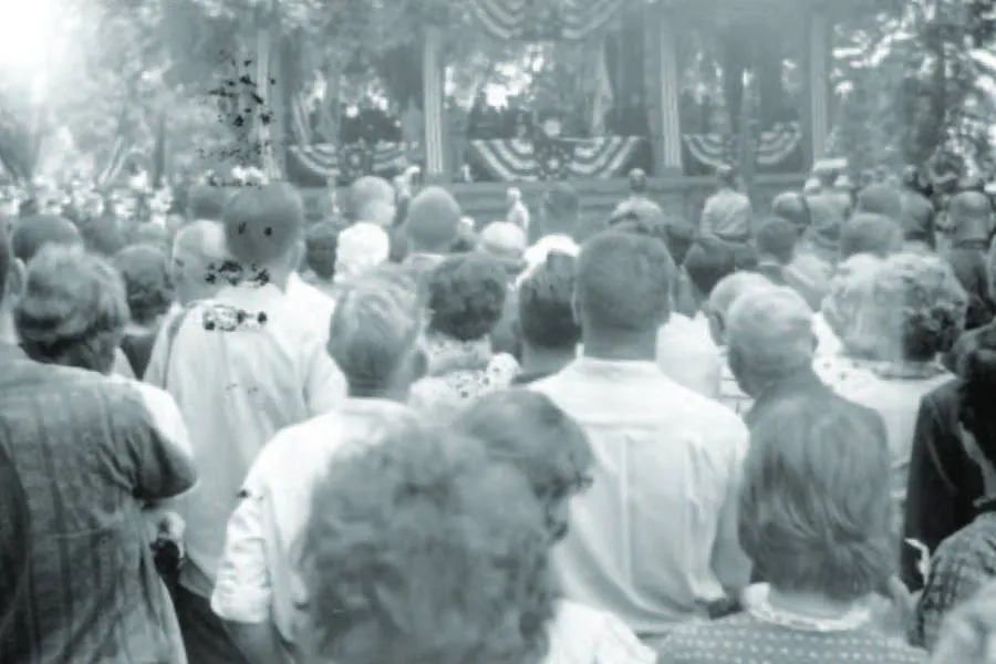 historical black and white photo of crowd gathered in front of stage