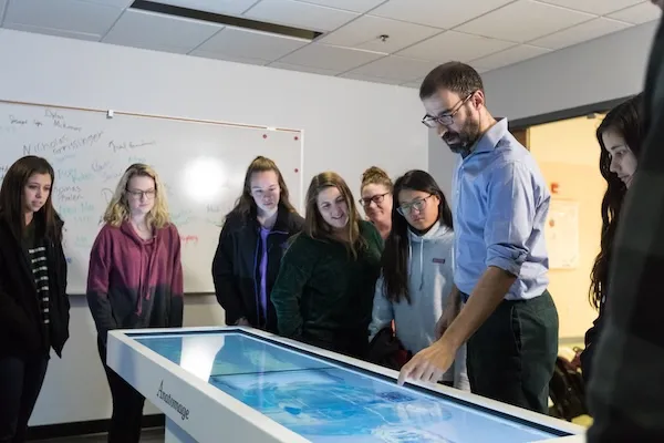prof teaches group of students at anatomage table