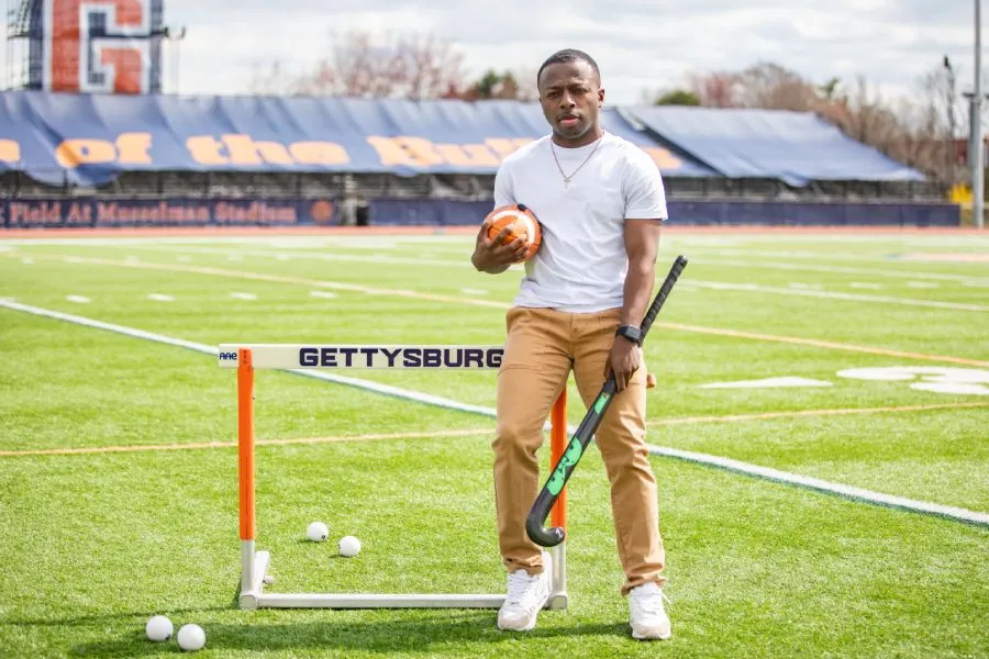 male student on field with sporting equipment