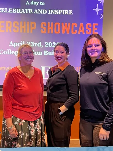 women pose in front of screen at leadership showcase