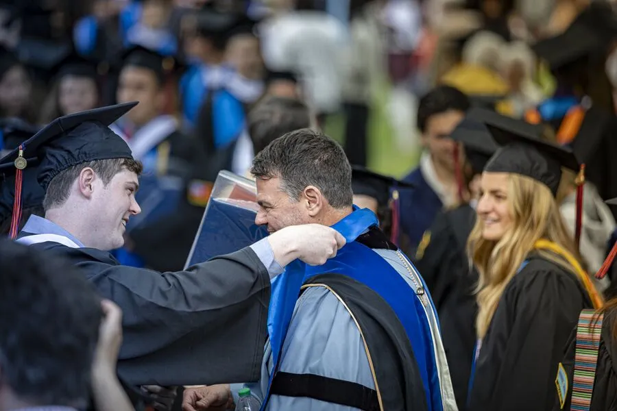 Prof. Downs being given a Stole of Gratitude by a graduate at the Class of 2024 Commencement ceremony.