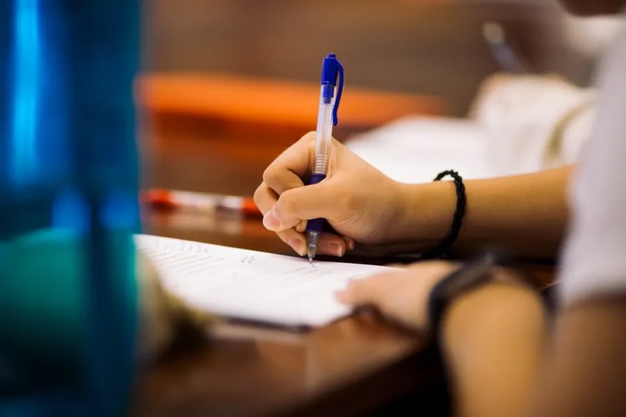 A student writing on a book