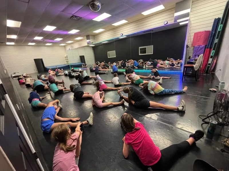 Youth dancers stretch before taking part in a free dance class in collaboration with The Edge Dance Complex and Kendall DeShong ’28.