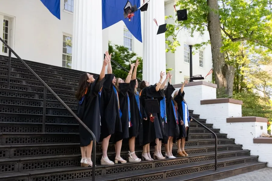 Gettysburg’s newest graduates toss their caps in the air on the steps of Pennsylvania Hall.