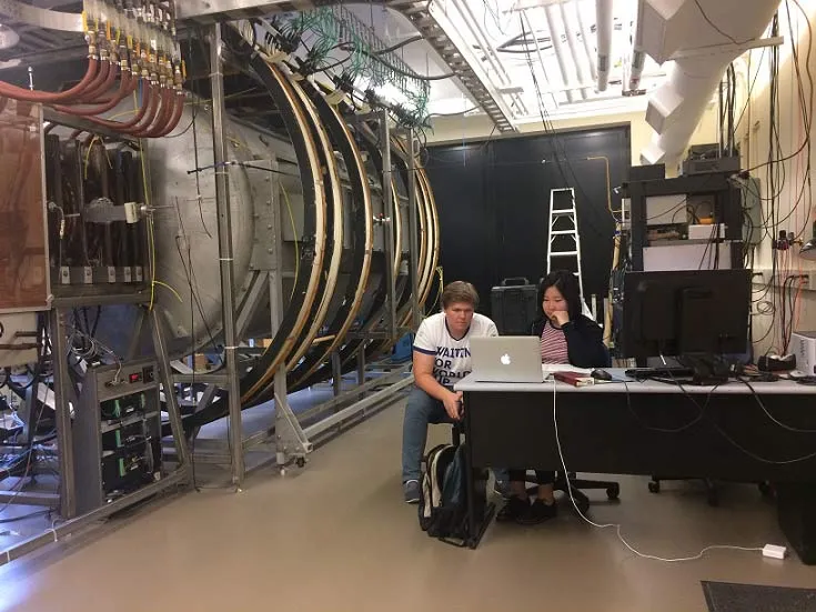 Student researcher working with a plasma apparatus in a laboratory