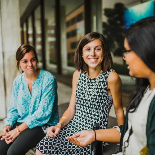 Three women sitting and talking outdoors