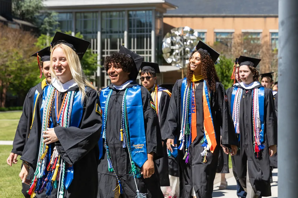 A group of graduates walking down the pathway