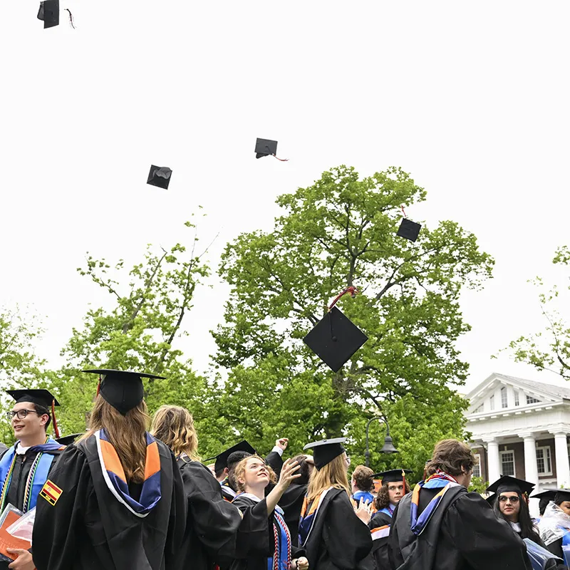 Graduates toss their caps into the air during a commencement ceremony.
