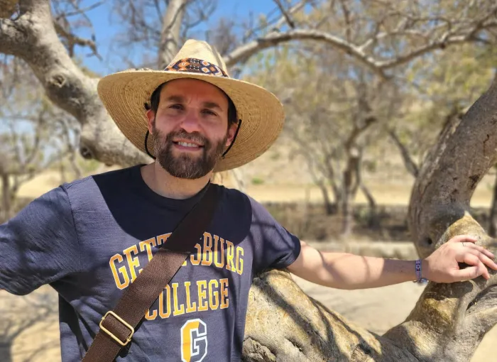 prof outdoors in hat