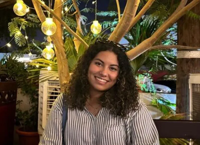 student in front of tree lights