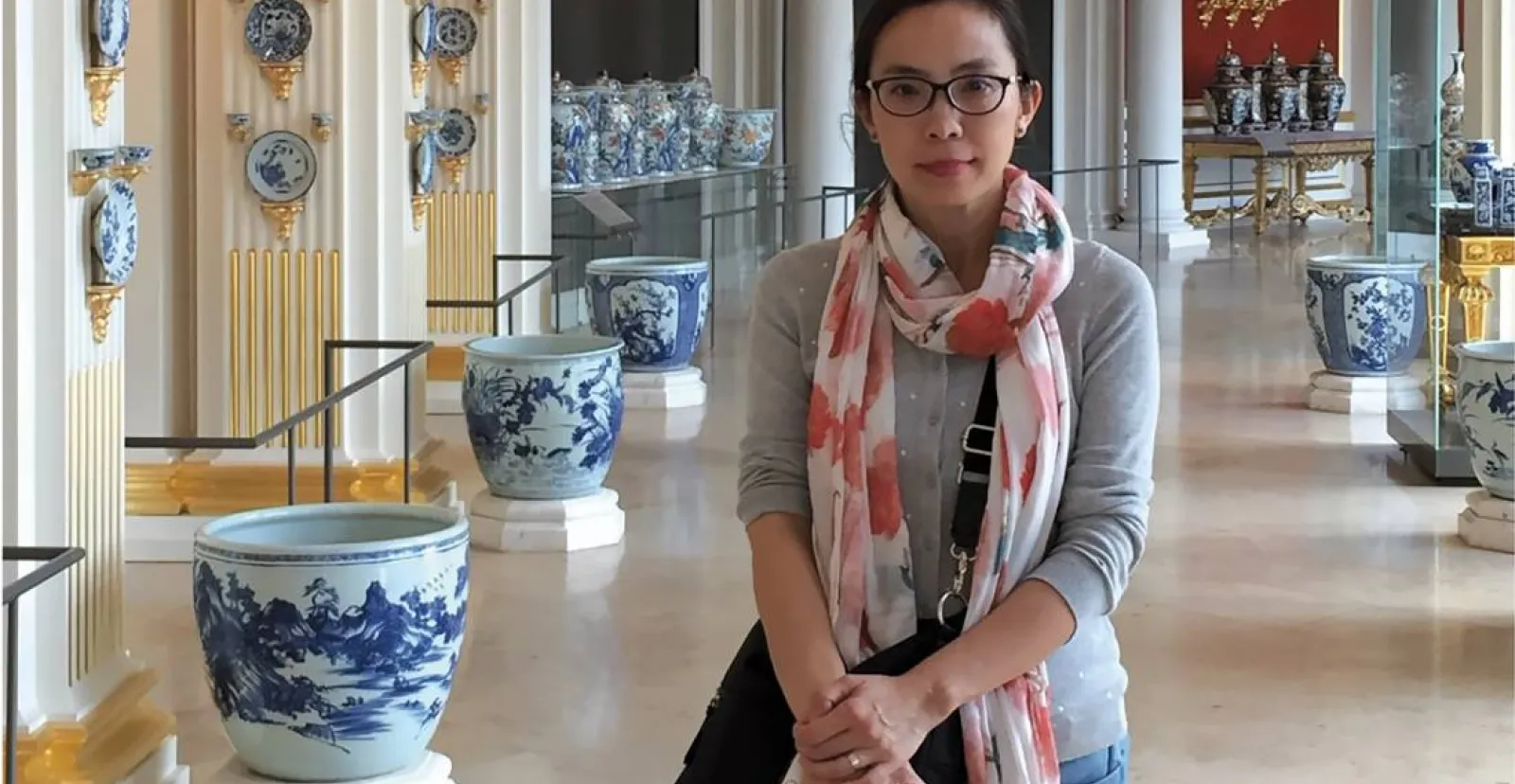 Yan Sun at a museum with asian pottery behind her in the background