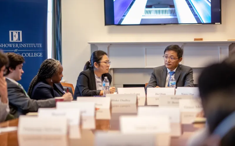 students sit at table with Chinese dignitary