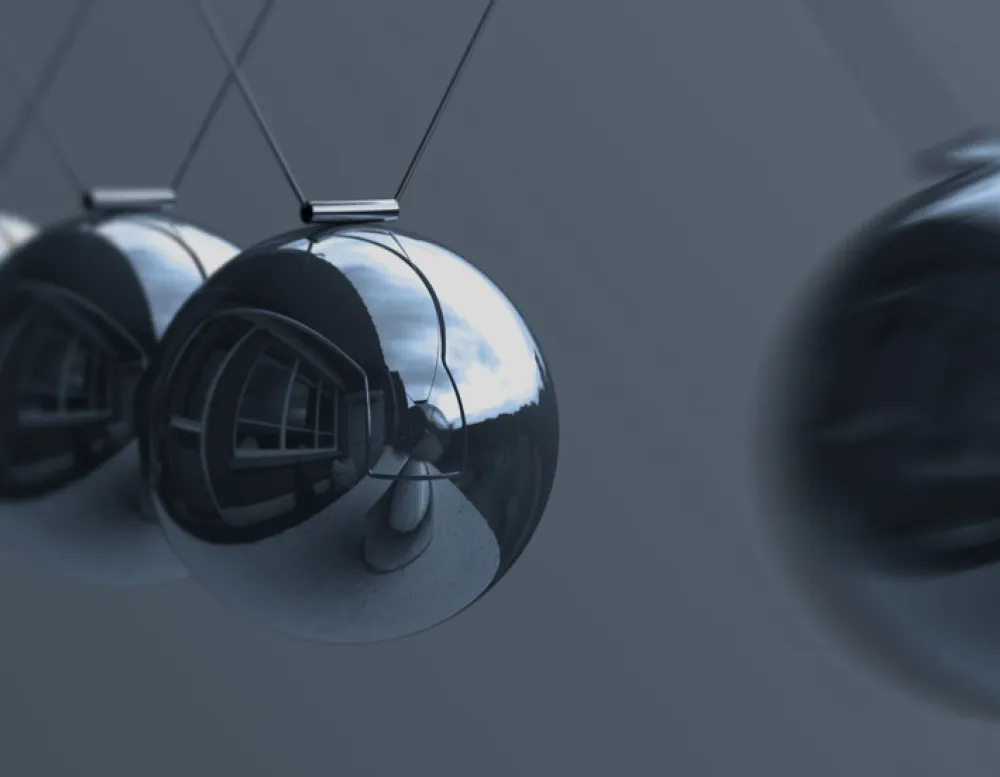 silver balls dangle from suspension wires and reflect foreground